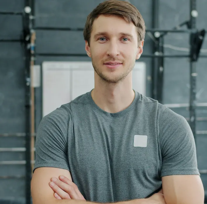 A gym owner standing with his arms crossed in his training studio